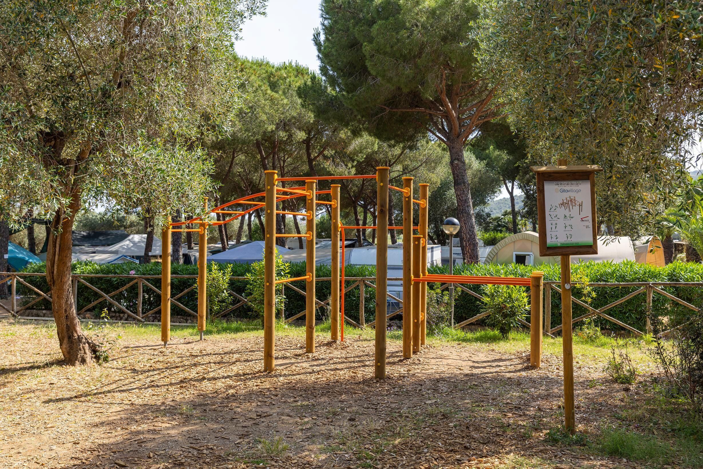 An outdoor playground with climbing structures and a signboard.