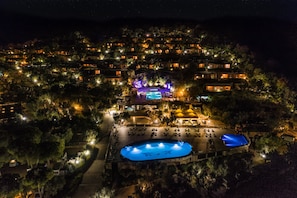 Um resort com vários edifícios, piscina e área de palco.