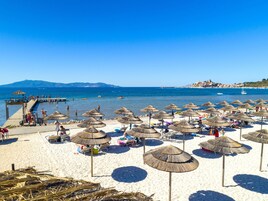 En la playa, sillas reclinables de playa, sombrillas