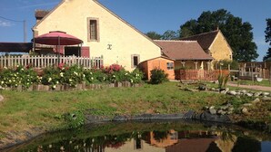 A two-story building with a red awning and a small adjacent structure. - Domaine de la Haute Poignandière (Saint-Germain-de-la-Coudre)