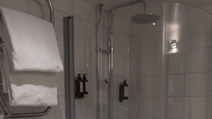 A modern bathroom with a glass-enclosed shower, a toilet, and a towel rack.