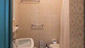 A bathroom with a sink, toilet, and shower area. - Colors Hostel (Toscolano Maderno)