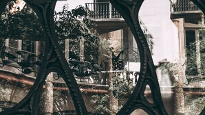 Un edificio de varios niveles con balcones de intrincada reja y una columnata central.