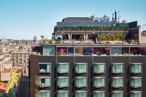 A modern building with a rooftop terrace featuring outdoor seating and potted plants. - The Barcelona EDITION (Barcelona)