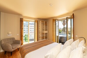 Une chambre à coucher avec un lit, une chaise, une armoire et une vue sur l’extérieur.