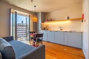 Une cuisine moderne avec un coin repas, un canapé et une vue sur la ville.