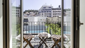 Ein Balkon mit Billardtisch, Stühlen und einem kleinen Tisch.