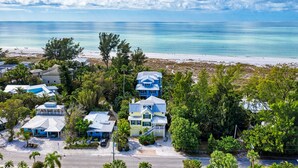 Une zone résidentielle côtière avec des maisons, une plage et un ciel dégagé.