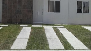 Un bâtiment moderne doté d’un toit plat, de grandes fenêtres et d’une entrée en béton.