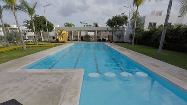 Une piscine rectangulaire avec des couloirs délimités, entourée d’une terrasse en béton.