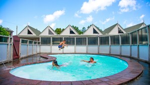 Une piscine bordée de briques et dont l’eau est d’un bleu cristallin.
