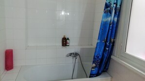 A bathroom with a bathtub, a shower, and a toilet. There are two bottles of shampoo and conditioner on the wall. - B&B Casa Felicità (Rome)