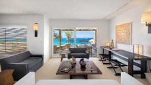 Een moderne woonkamer met een bank, een salontafel en uitzicht op zee.