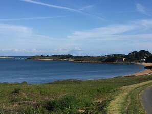 A coastal landscape with a clear sky, a sandy beach, and a grassy area. - Beautiful Breton farmhouse, Pink Granite Coast, sleeps 8, near beaches (Trébeurden)