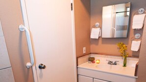 A bathroom with a shower, toilet, sink, and a towel rack. - Cheerful & Affordable Studio Apartment - Walking Distance to Beaches (Princeville)