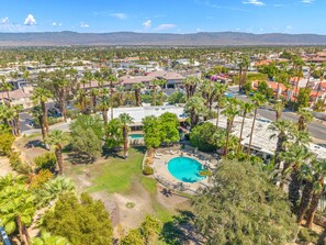 A residential area with a swimming pool surrounded by palm trees and houses. - El Paseo, 'The Rodeo Drive of Beverly Hills' In Palm Desert. Free  Wi FI (Palm Desert)
