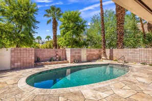 A swimming pool with a tiled deck, surrounded by a brick wall and palm trees. - El Paseo, 'The Rodeo Drive of Beverly Hills' In Palm Desert. Free Wi FI (Palm Desert)