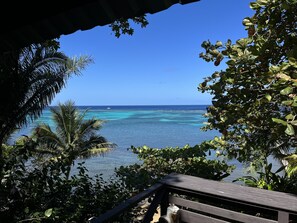 Blick auf das Meer von einer überdachten Terrasse mit Holzdeck.