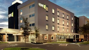 A modern hotel with a prominent "HOME 2" sign, a covered entrance, and a well-lit facade. - Home2 Suites by Hilton Sarasota - Bradenton Airport, FL (Sarasota)