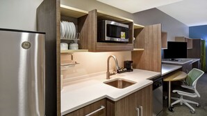 A modern kitchen with a stainless steel refrigerator, a microwave, and a sink.