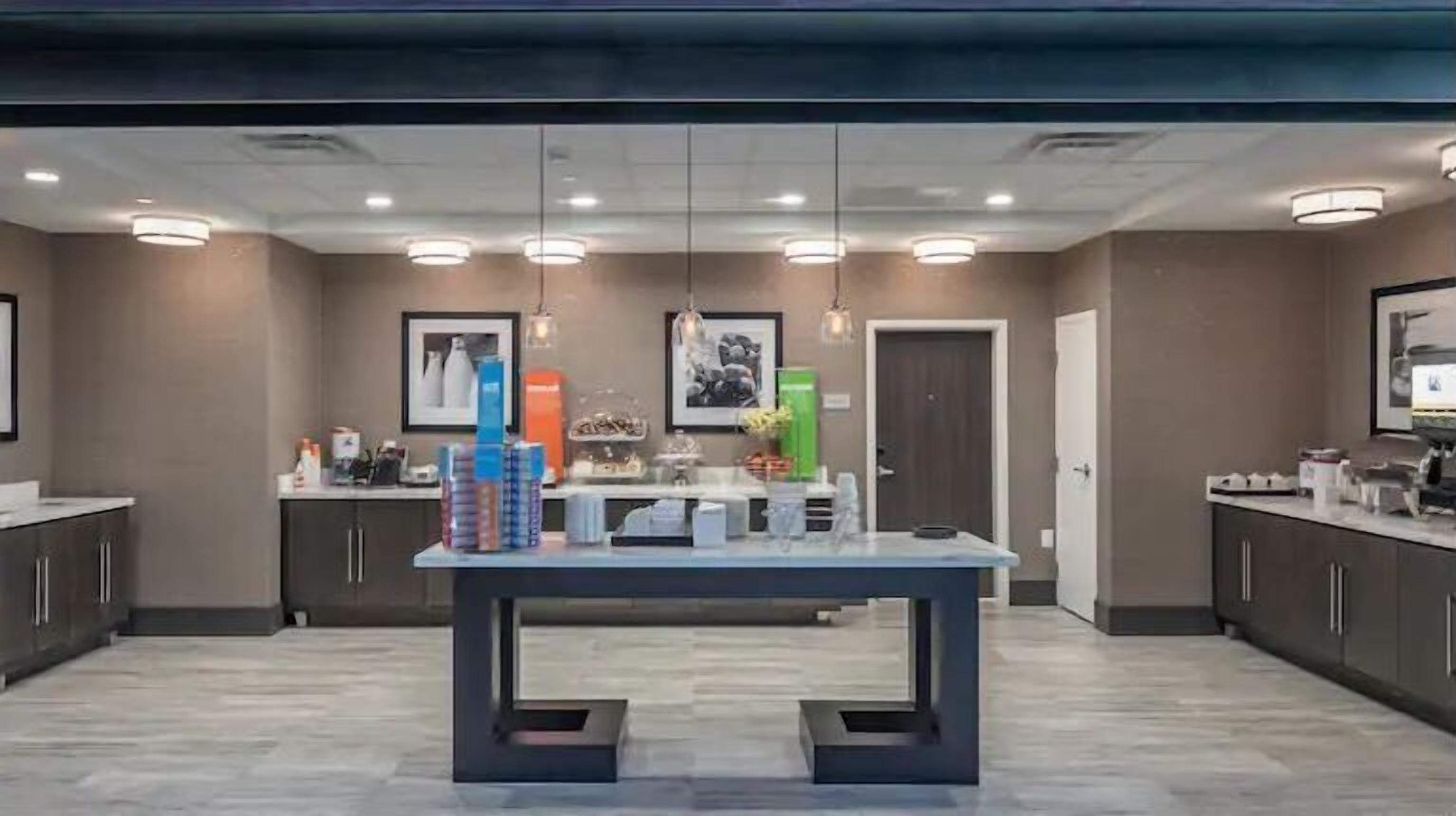 A modern kitchen with a central island, dark cabinets, and a tiled floor.