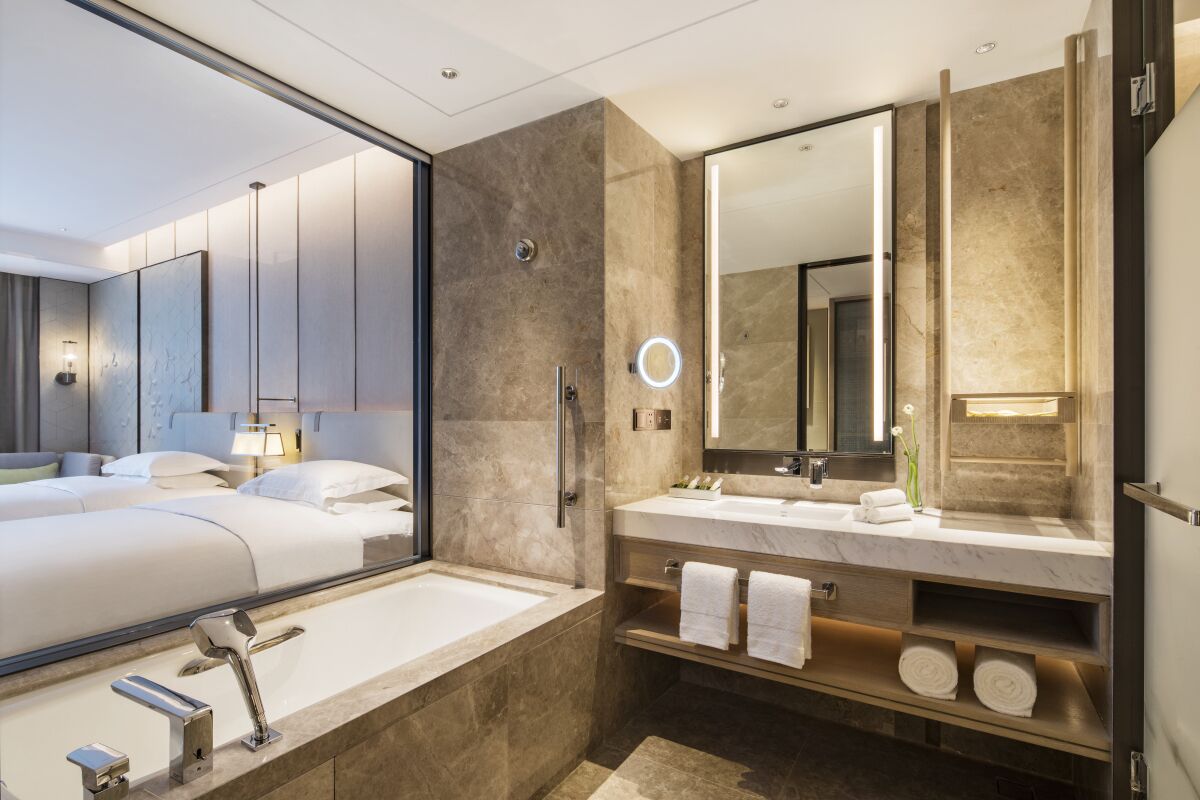 deluxe twin room | bathroom | separate bathtub and shower, rainfall showerhead, designer toiletries