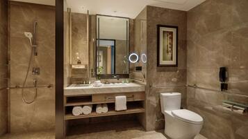 A modern bathroom with a shower, toilet, and vanity.