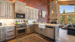 A modern kitchen with stainless steel appliances, wooden cabinets, and a stone backsplash. - Clearview 2 - Amazing Tahoe Views, Dog Friendly, Pool Table, Near Golf (Tahoe City)