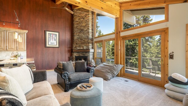A cozy living room with a fireplace, comfortable seating, and large windows offering a view of the outdoors. - Clearview 2 - Amazing Tahoe Views, Dog Friendly, Pool Table, Near Golf (Tahoe City)