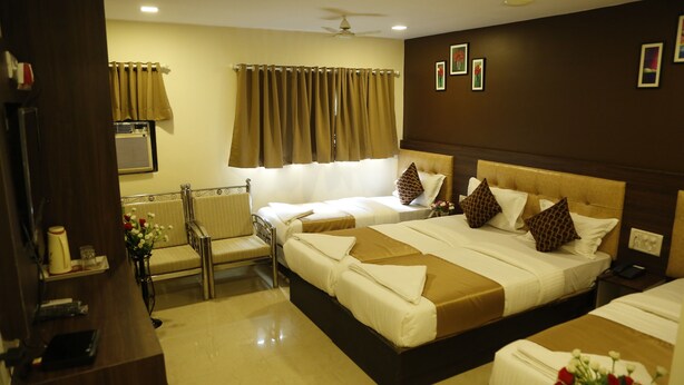 A hotel room with a large bed, a desk, a chair, and a window with curtains. - Hotel Royal Onix Mumbai (Mumbai)