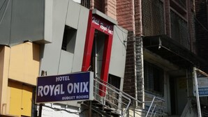 A hotel sign for Royal Onix Budget Rooms, with a red and white color scheme and a modern architectural design. - Hotel Royal Onix Mumbai (Mumbai)
