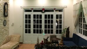 Een gezellige woonkamer met een stenen muur, een dartbord, een kleine kerstboom en een bank.