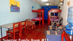 A family room with bunk beds, a table, chairs, and a water dispenser. - Rositas Hotel (San Juan del Sur)