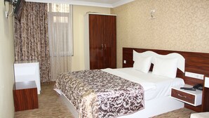 A hotel room with a bed, a wardrobe, a desk, and a chair. - Sinan Hotel (Ankara)