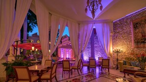 A luxurious indoor setting with elegant furniture, a patterned carpet, and a chandelier. - El Palacito Secreto (Mérida)