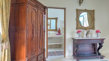 Habitación con armario de madera, tocador decorado, espejo y baldosas de piso estampado.