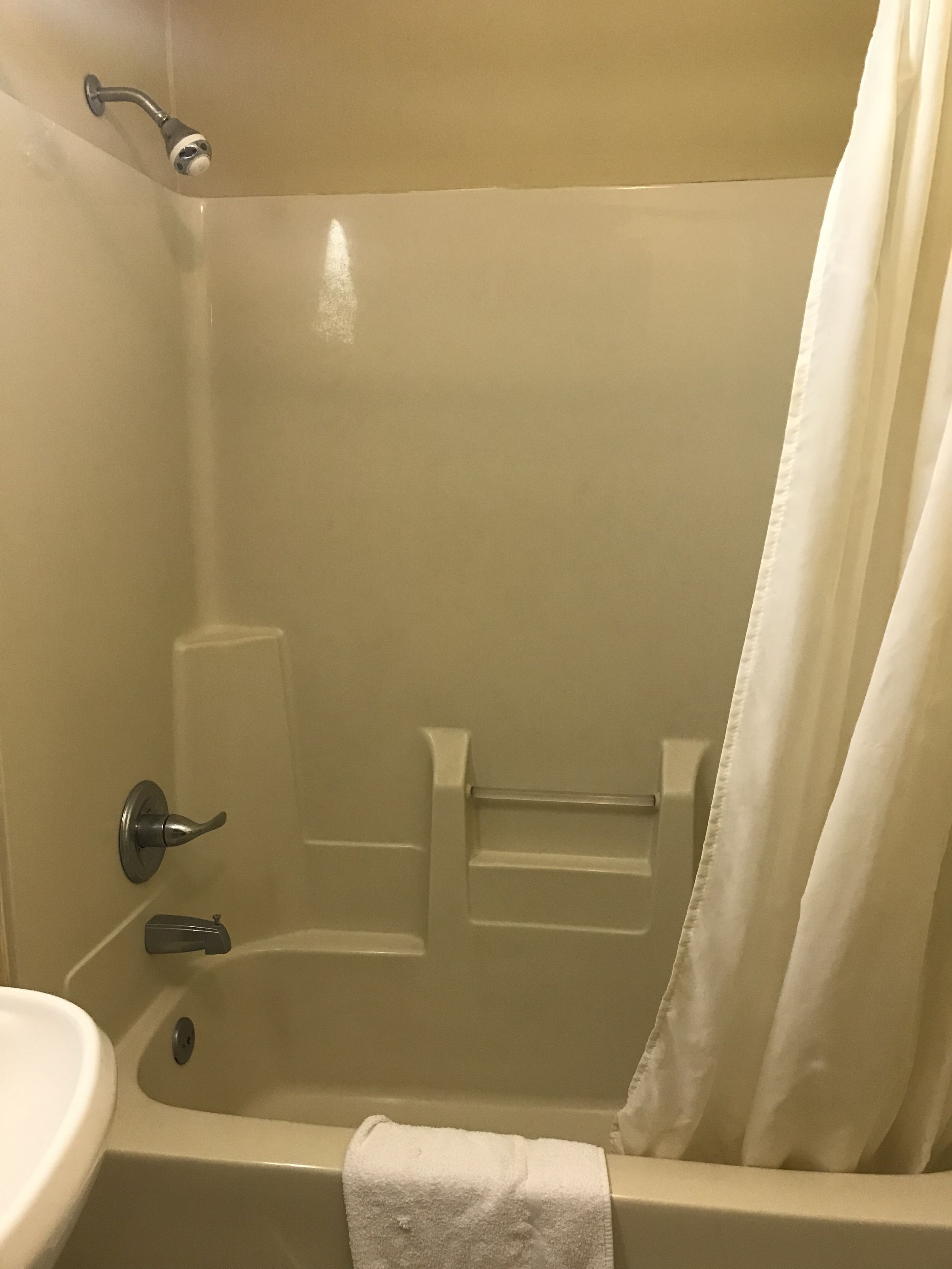A bathroom with a bathtub, a sink, and a shower curtain.