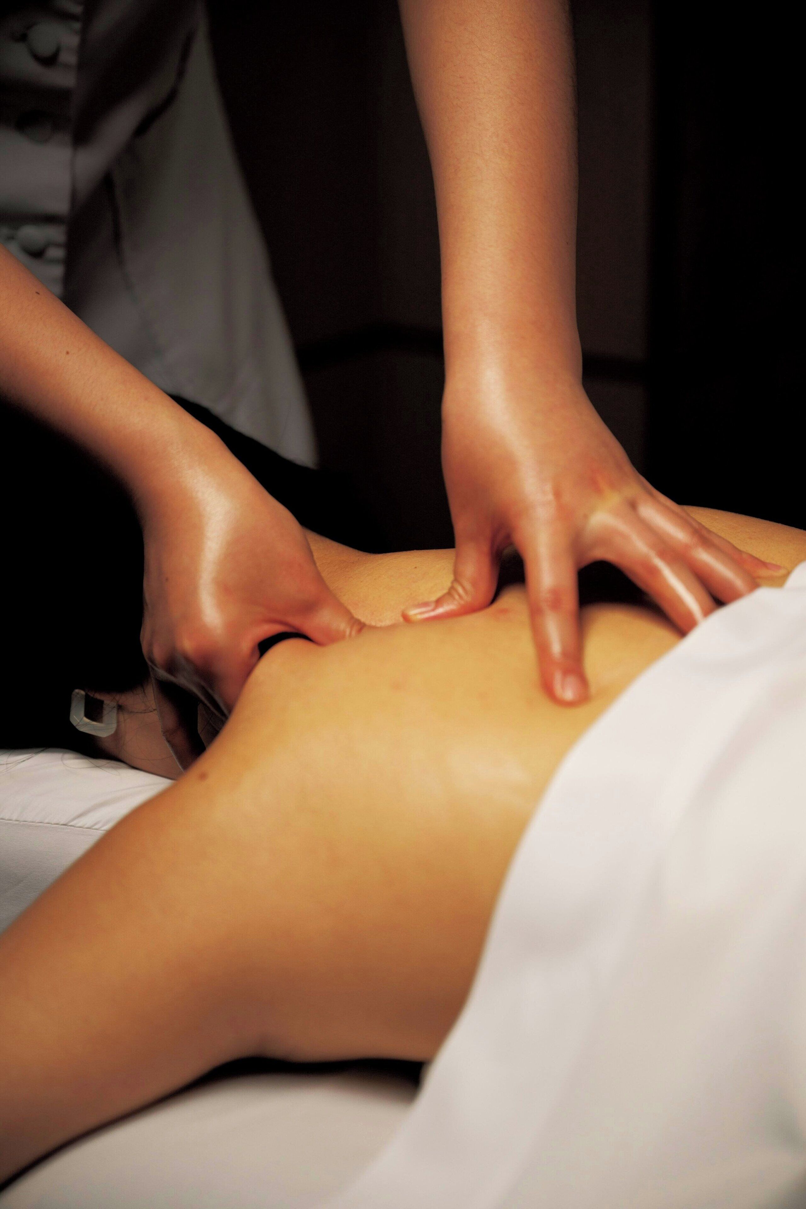 A person receiving a massage on a massage table.