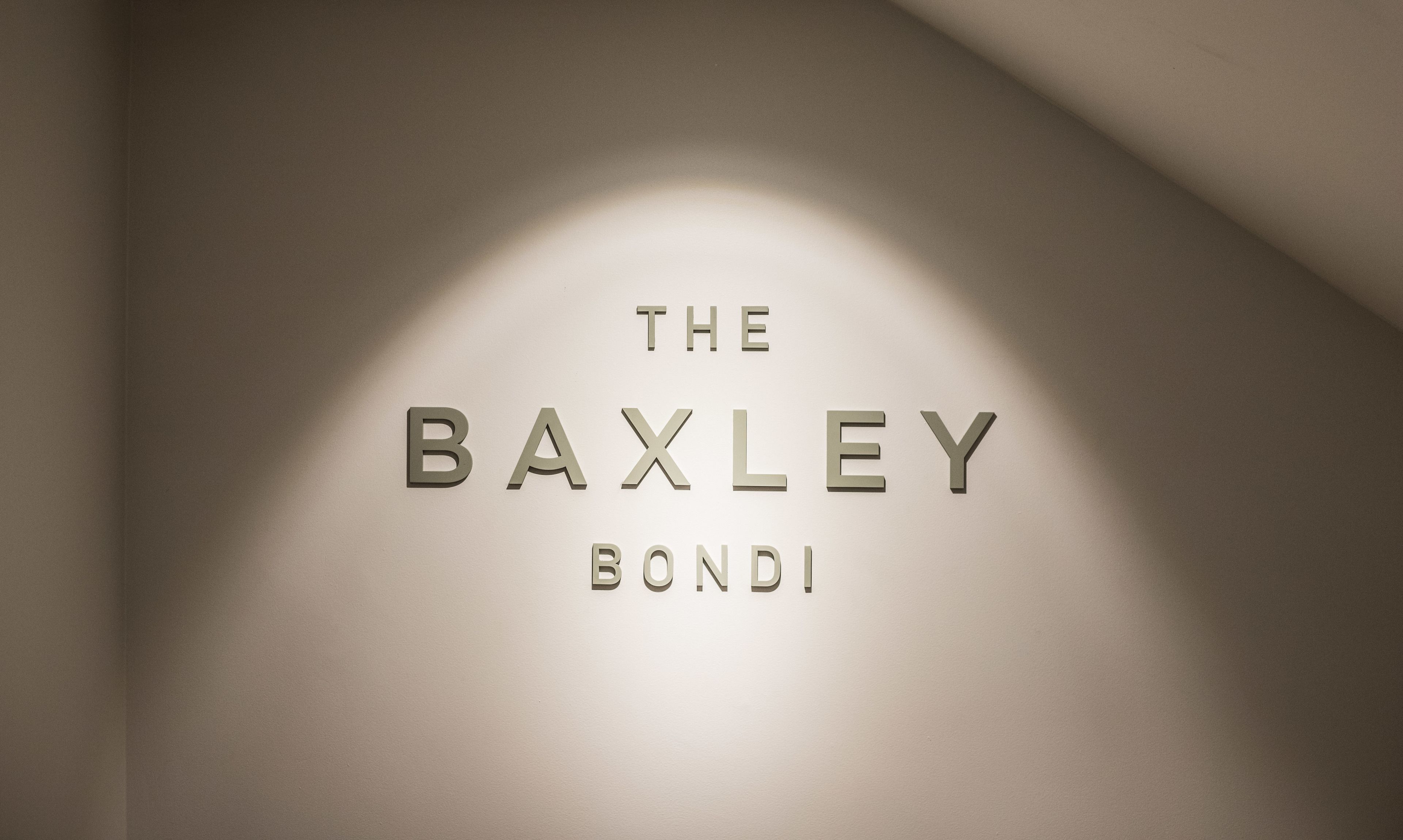 A wall with the text "THE BAXLEY BOND" in a modern font.