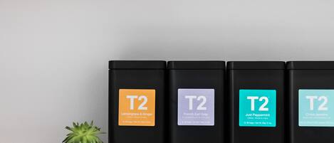 Four black boxes labeled T2 on a wooden shelf.