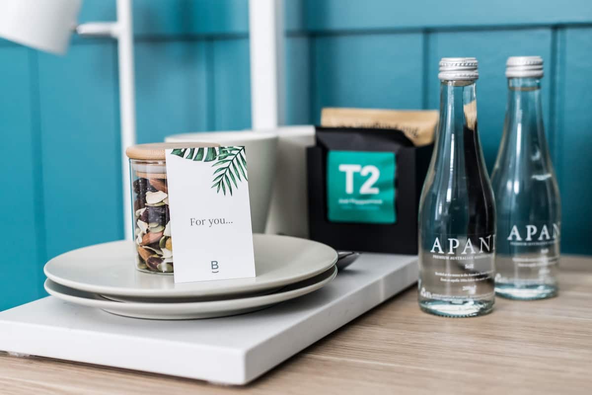 A table with a jar of nuts, a card, and two bottles of water labeled 'APAN'.