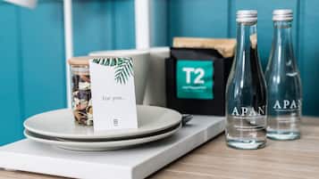 A table with a jar of nuts, a card, and two bottles of water labeled 'APAN'.