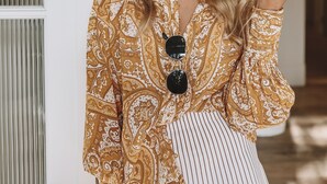 A person standing in a doorway with a patterned blouse and striped pants. - The Baxley Bondi (Bondi)