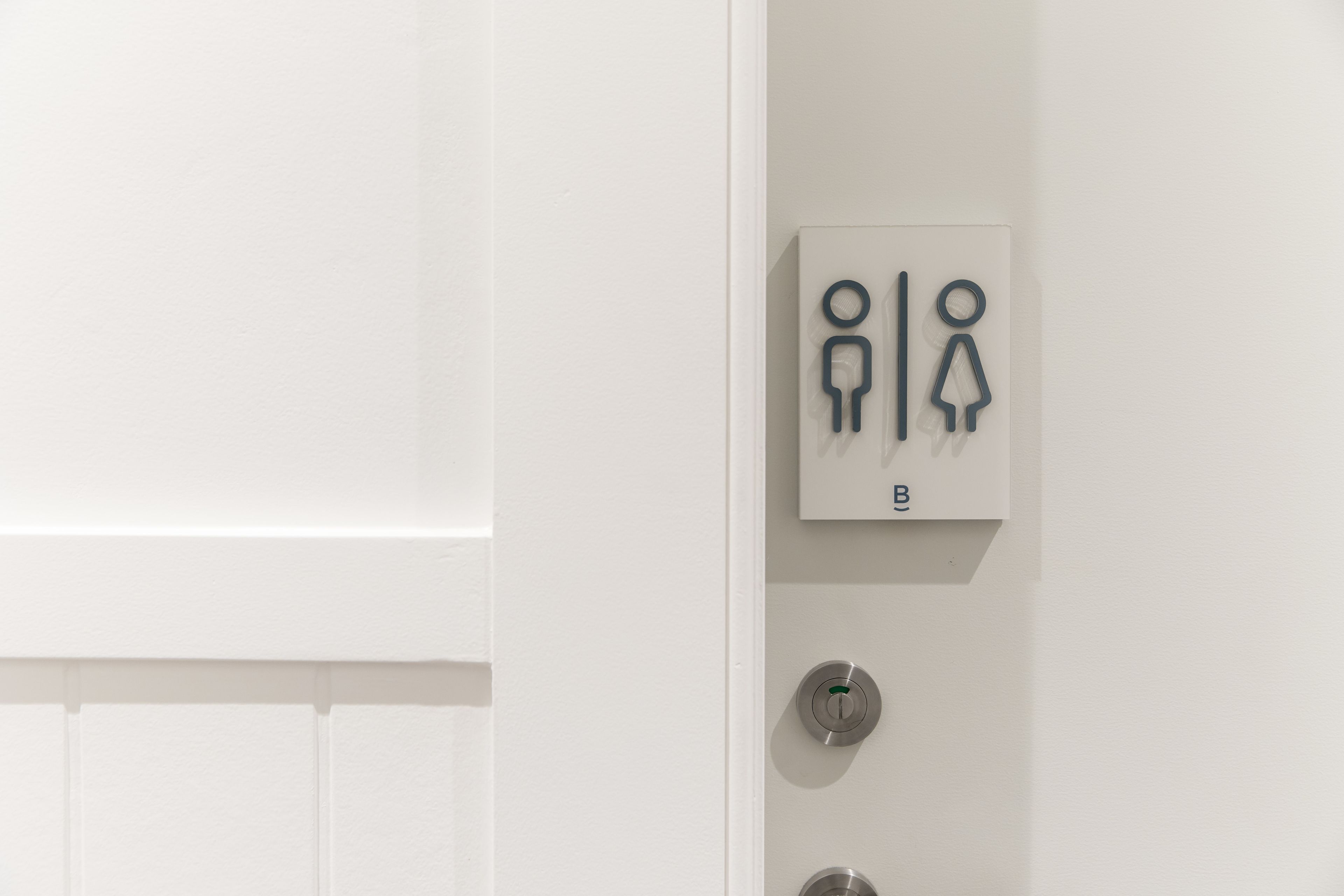 A door with a gender-neutral bathroom sign and a keyhole.