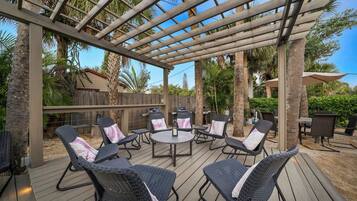 An outdoor patio with wicker furniture and a pergola.