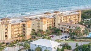 A coastal hotel with multiple buildings, a beach, and a pool area. - Amazing NEW 1BR APT just Steps to the Beach! Unit 312 (Cocoa Beach)