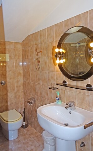 A bathroom with a toilet, bidet, sink, and mirror. - Casa Olga Pieve Vista Lago (Tremosine)