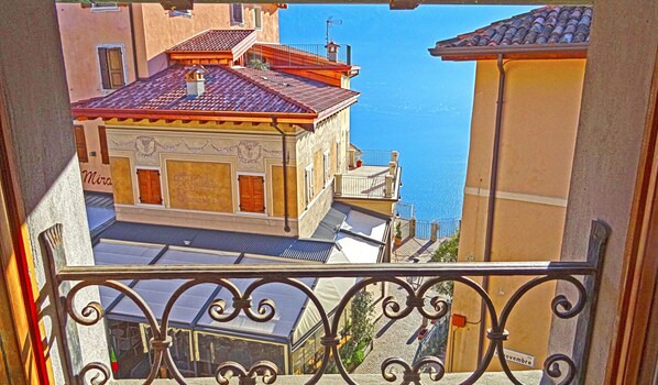 A building with a tiled roof and a balcony with wrought iron railings. - Casa Olga Pieve Vista Lago (Tremosine)
