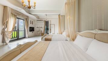 A spacious bedroom with a large bed, a chandelier, and a view of a balcony.