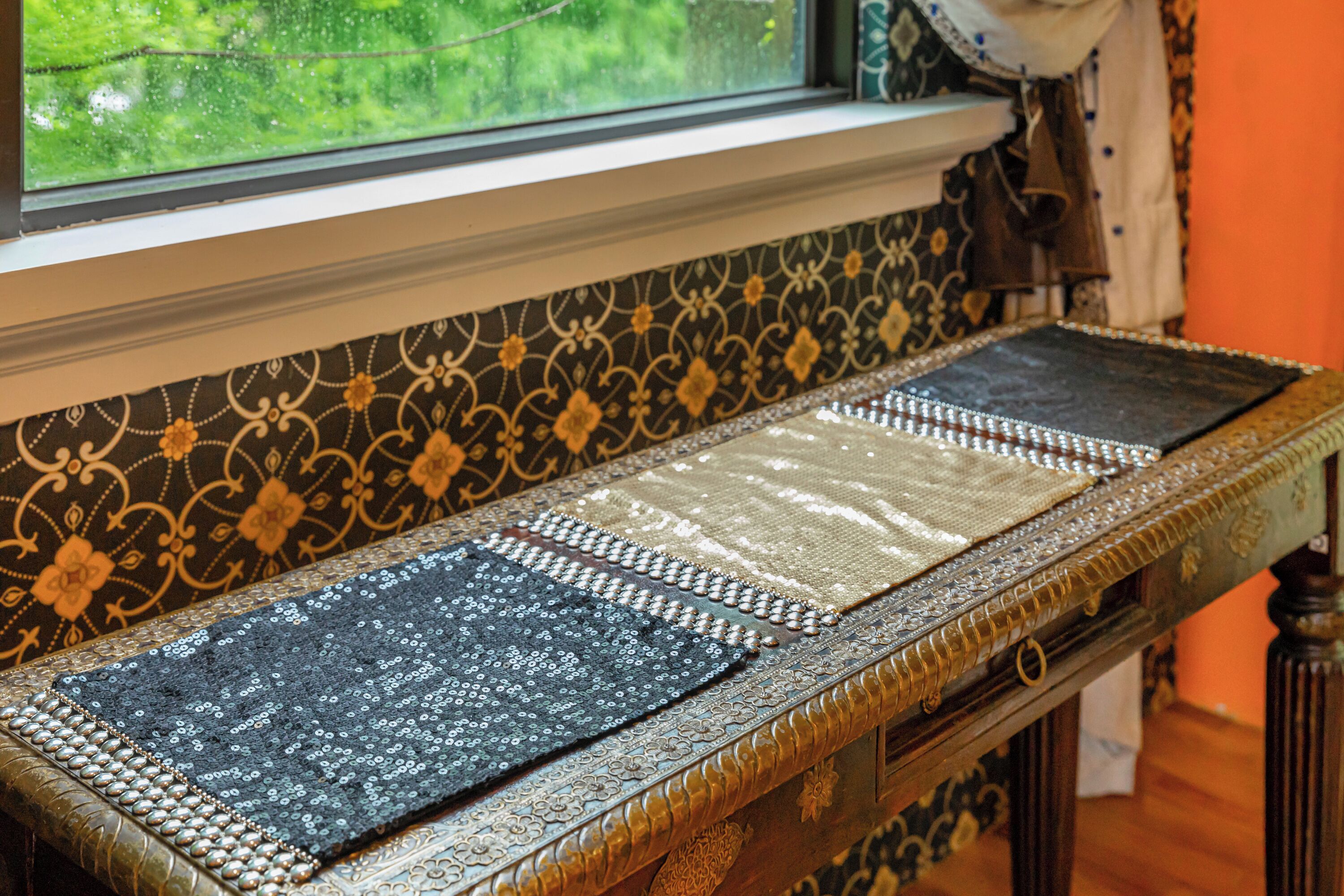 A table with a decorative table runner and a patterned tablecloth.